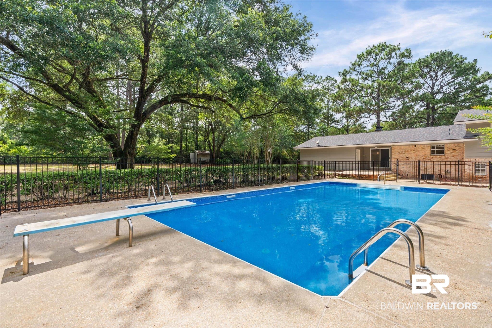 8301 Fordham Road Mobile, AL 36619 - Photo 31 of 57 Expansive inground pool featuring a diving board, metal handrails, and surrounding concrete decking