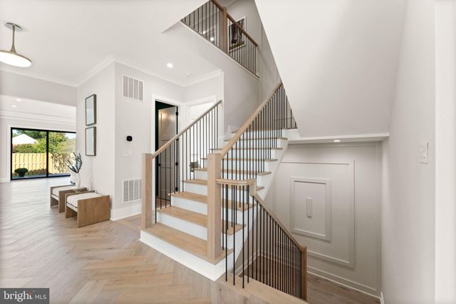 a living room with furniture a glass table and kitchen view