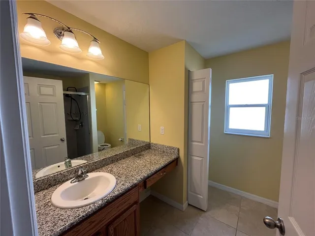 a bathroom with a granite countertop sink and a mirror