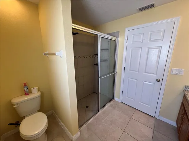 a bathroom with a granite countertop toilet and a shower