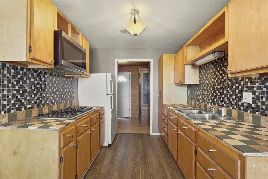 1556 John Wayne Road Kaufman, TX 75142 - Photo 24 of 33 a kitchen with sink cabinets and wooden floor