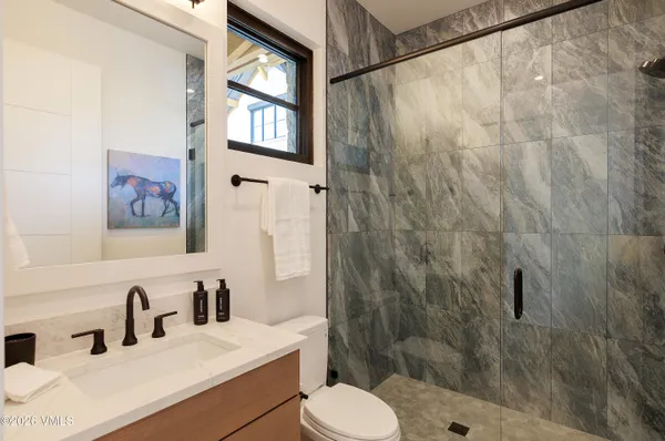 a bathroom with a sink toilet a mirror and shower