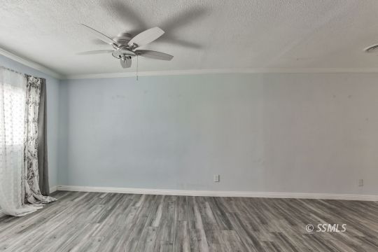 1415 Mayo Street Ridgecrest, CA 93555 - Photo 23 of 34 an empty room with wooden floor fan and windows