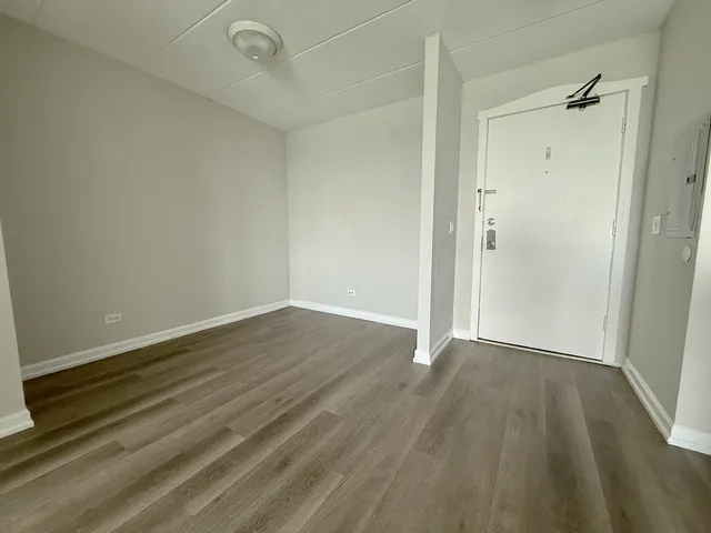 a view of an empty room with wooden floor