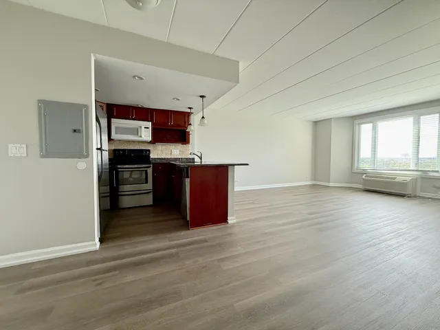 an empty room with wooden floor and cabinet