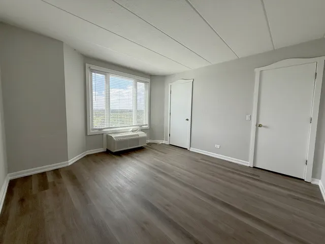 a view of a room with wooden floor and window