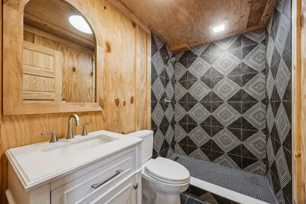 a bathroom with a granite countertop sink toilet and shower