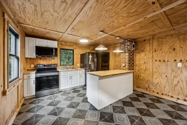 a large white kitchen with a stove a sink and dishwasher