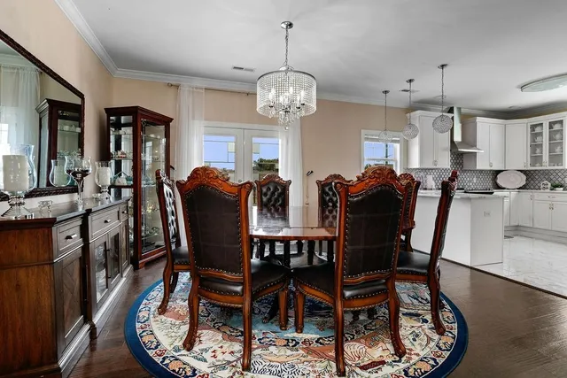 a kitchen with a dining table and chairs with wooden floor