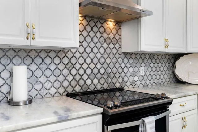 a kitchen with a stove and white cabinets