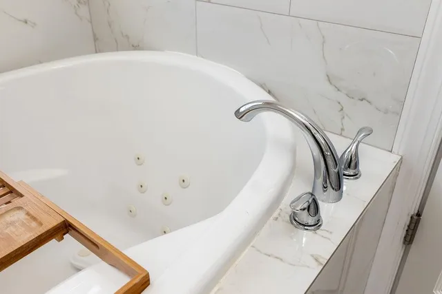 a view of an empty room with window chandelier fan and a window