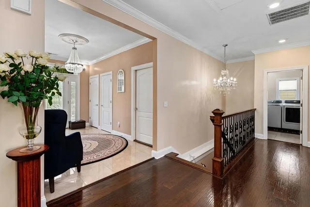 a view of a hallway with furniture and a chandelier
