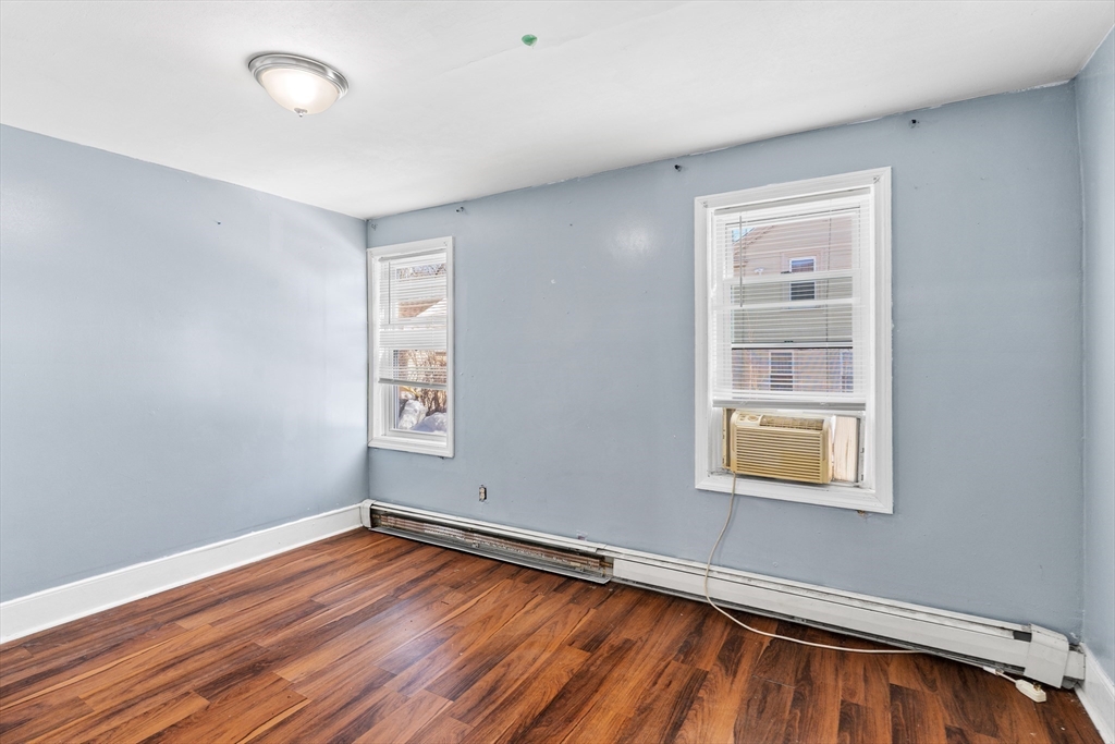 192 East Spring Street Avon, MA 02322 - Photo 11 of 25 an empty room with wooden floor and windows