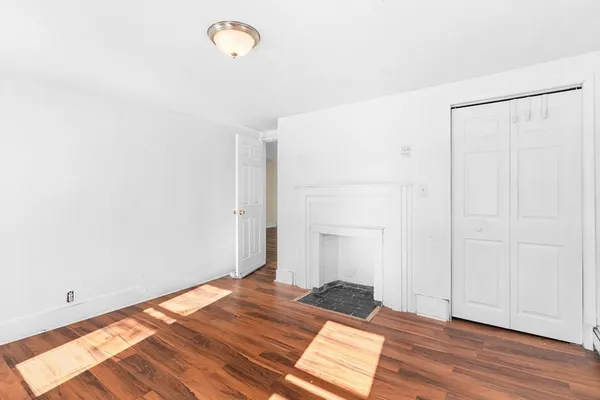 a view of a bedroom with wooden floor
