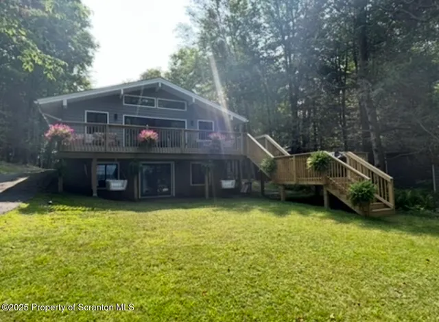 a view of a house with a yard and large tree