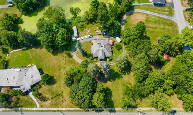 an aerial view of residential house with outdoor space and trees all around