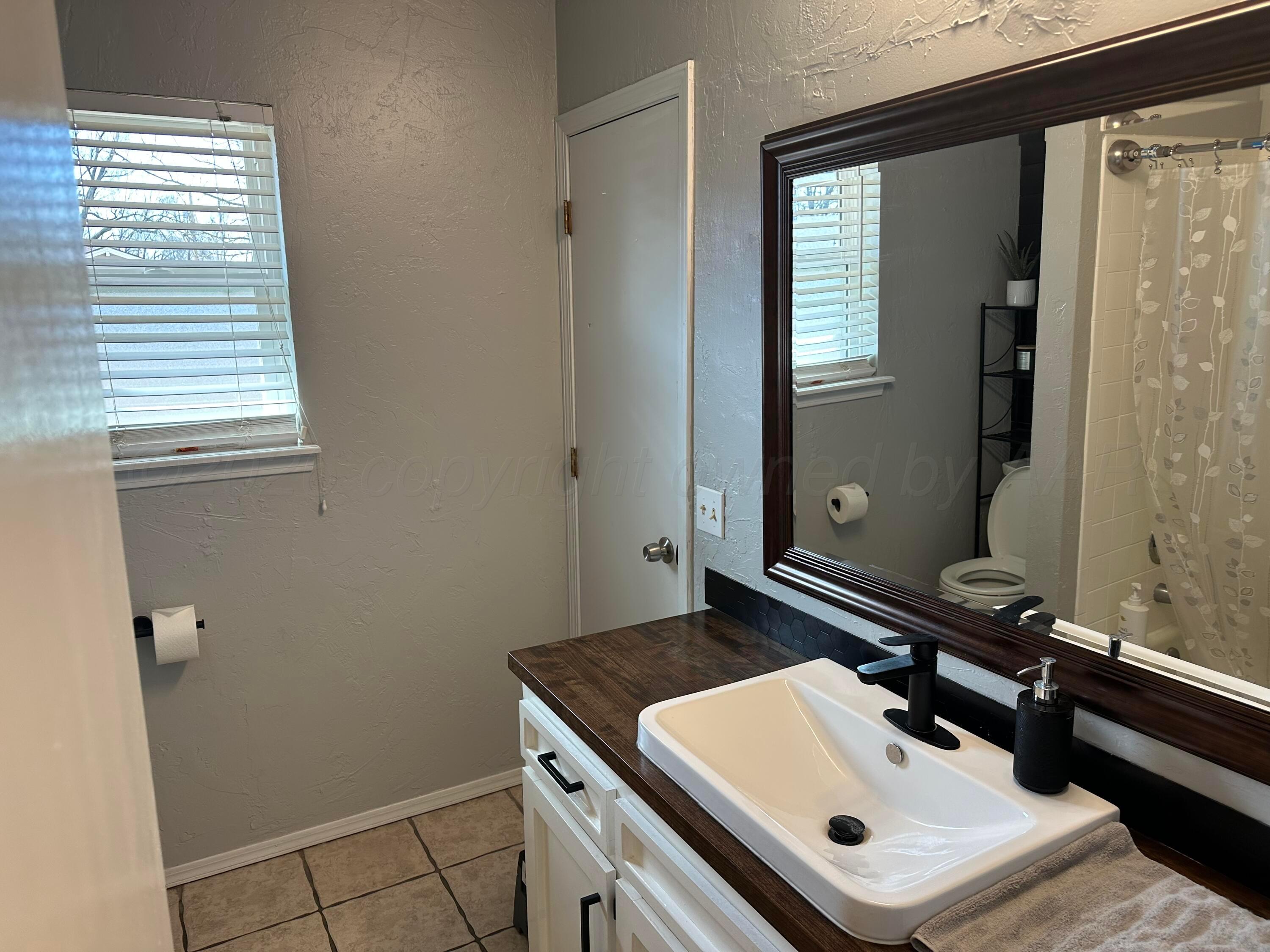 103 Somerset Street Borger, TX 79007 - Photo 13 of 23 a bathroom with a sink and a mirror