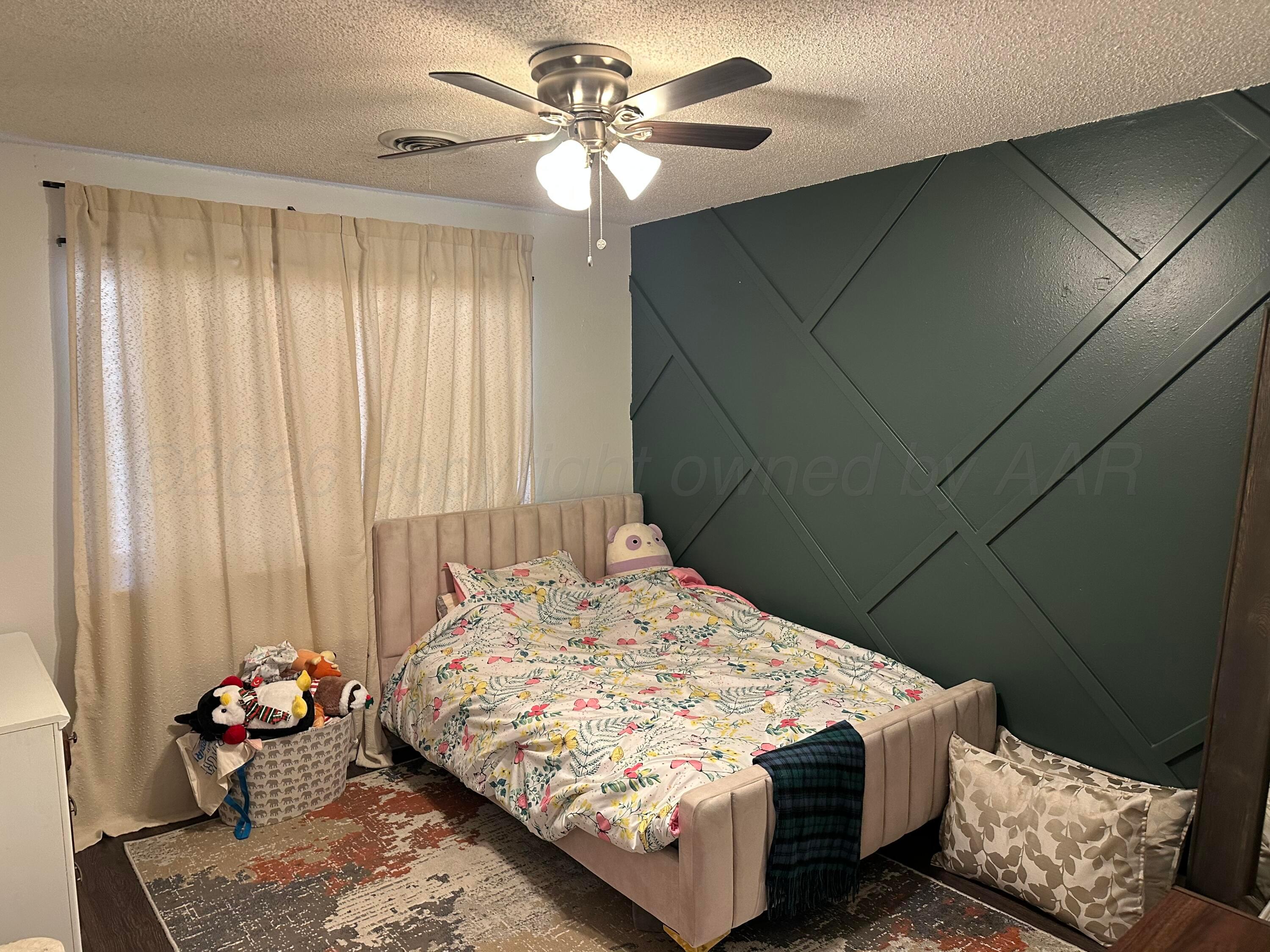 103 Somerset Street Borger, TX 79007 - Photo 14 of 23 a bedroom with a bed and a chandelier