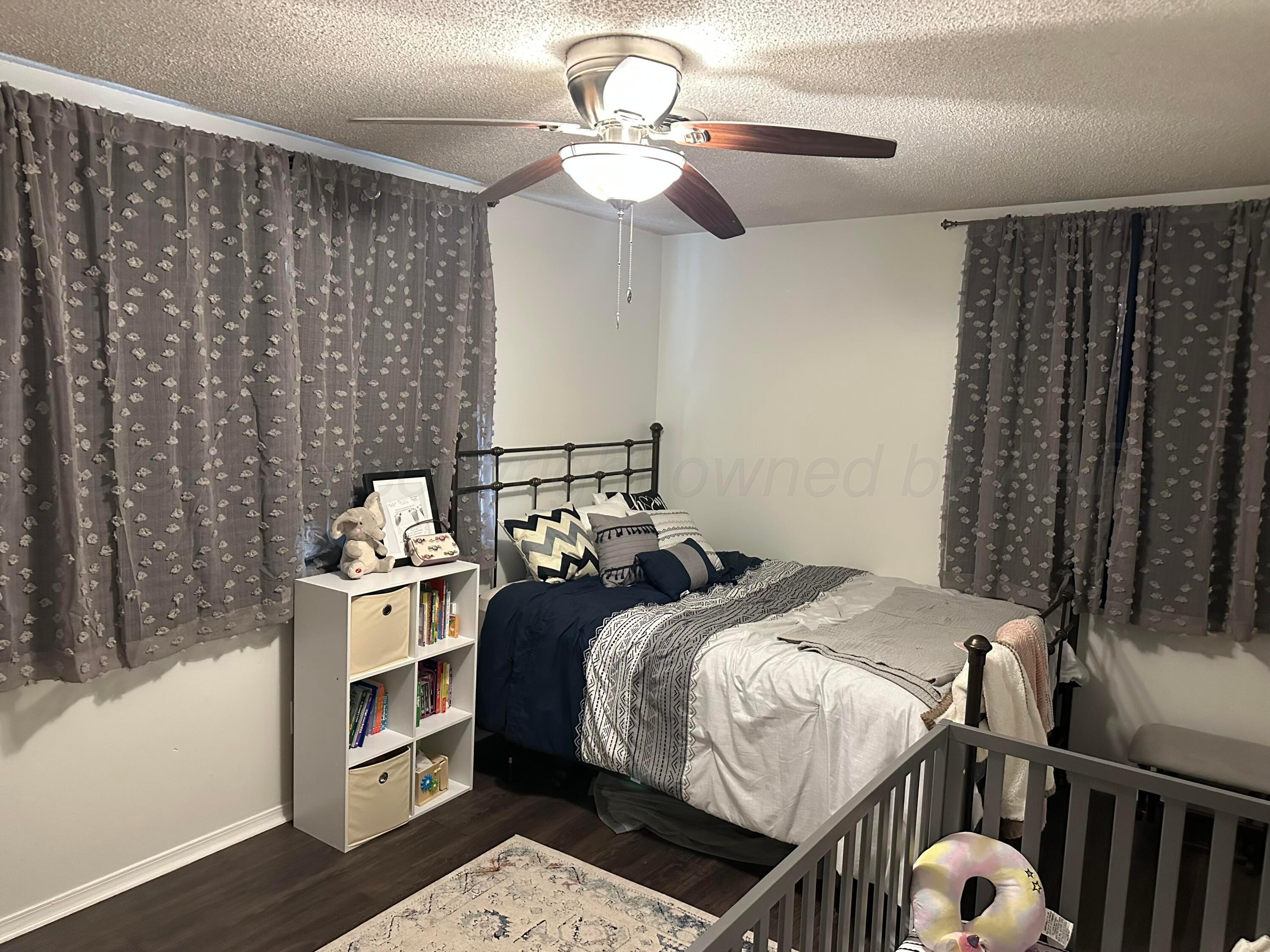 103 Somerset Street Borger, TX 79007 - Photo 15 of 23 a bedroom with a bed and a chandelier