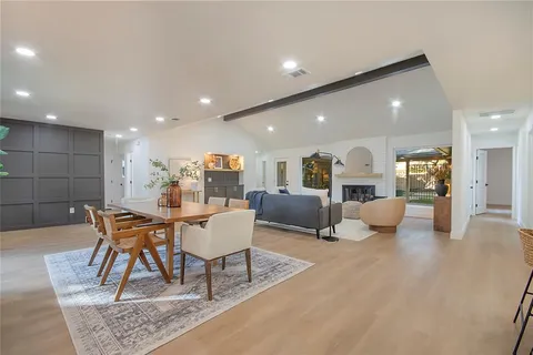 a living room with furniture and kitchen view with wooden floor