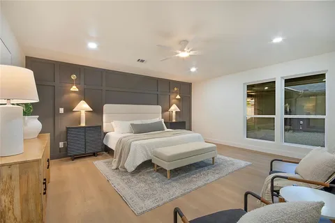 a spacious bedroom with a bed and glass window