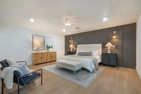 a spacious bedroom with a bed a couch and dresser