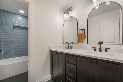 a bathroom with a double vanity sink and a mirror