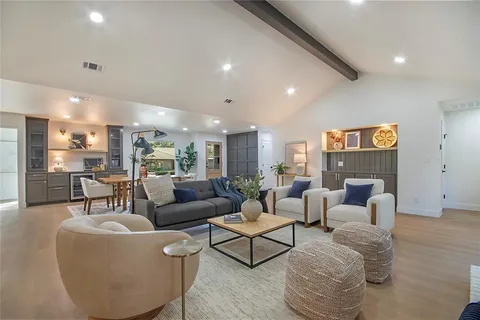 a living room with furniture and view of kitchen