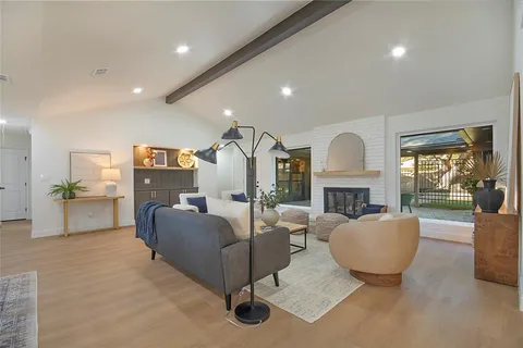 a living room with furniture a fireplace and a floor to ceiling window