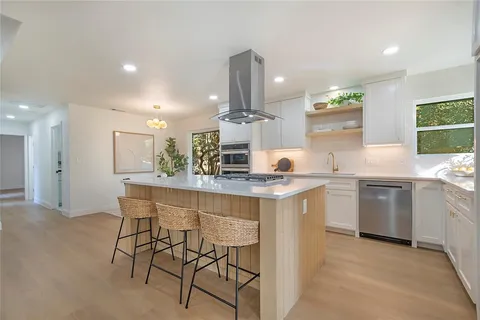 a kitchen with stainless steel appliances kitchen island granite countertop a sink and cabinets