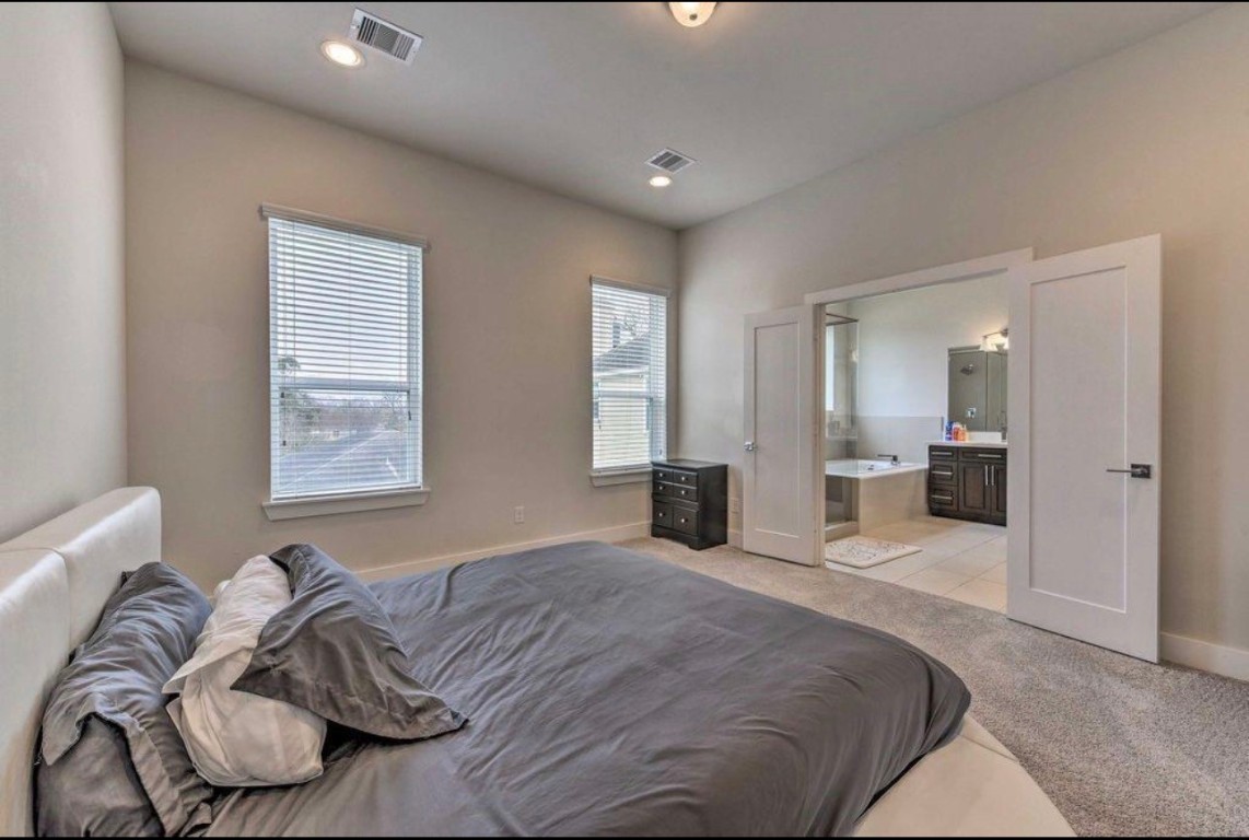 2107 Stuart Street Houston, TX 77004 - Photo 17 of 30 a bedroom with a bed and a mirror