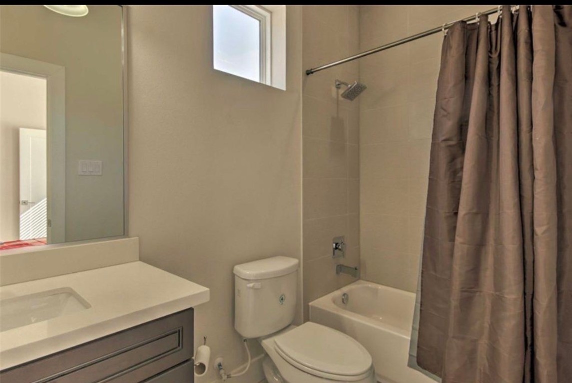 2107 Stuart Street Houston, TX 77004 - Photo 23 of 30 a bathroom with a sink a toilet a mirror and shower