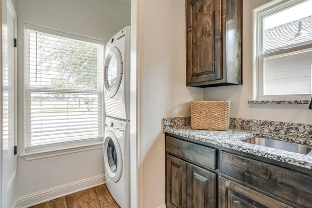 a utility room with granite countertop cabinets washer and dryer