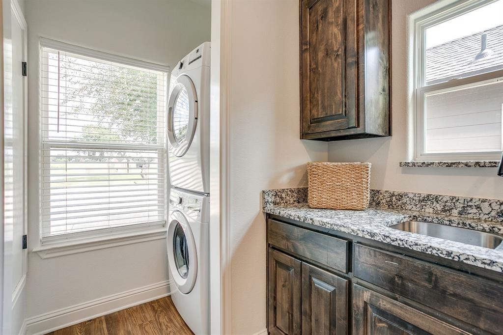 2706 James Road Granbury, TX 76049 - Photo 12 of 23 a utility room with granite countertop cabinets washer and dryer