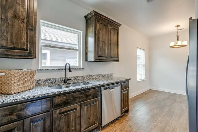 a kitchen with granite countertop a sink a stove and cabinets