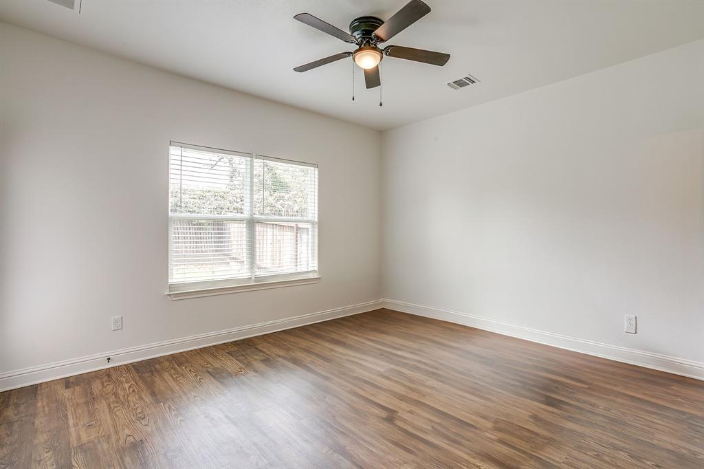 2706 James Road Granbury, TX 76049 - Photo 18 of 23 an empty room with wooden floor ceiling fan and windows