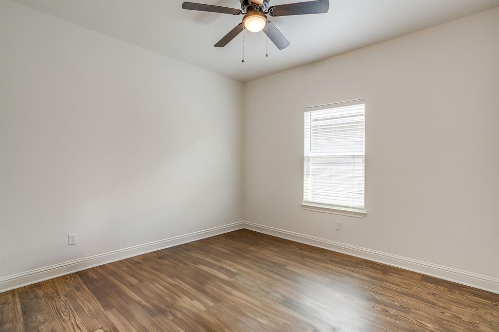 2706 James Road Granbury, TX 76049 - Photo 22 of 23 an empty room with wooden floor chandelier fan and windows