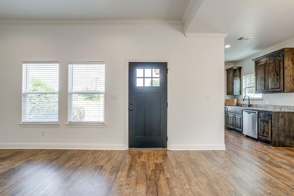 2706 James Road Granbury, TX 76049 - Photo 5 of 23 a view of a kitchen and an empty room with wooden floor and a kitchen