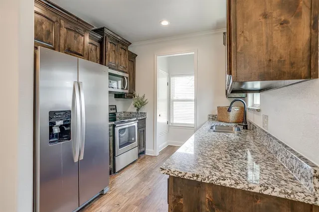 a kitchen with stainless steel appliances granite countertop a refrigerator and a stove