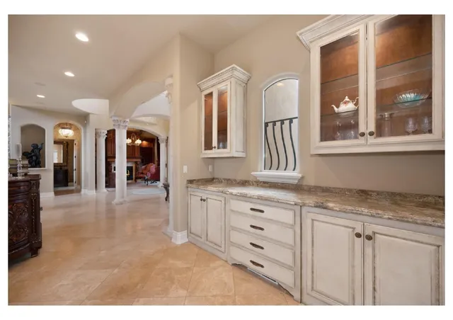 a living room with stainless steel appliances furniture and a kitchen view