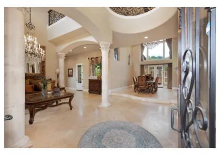 a living room with furniture a fireplace and a chandelier