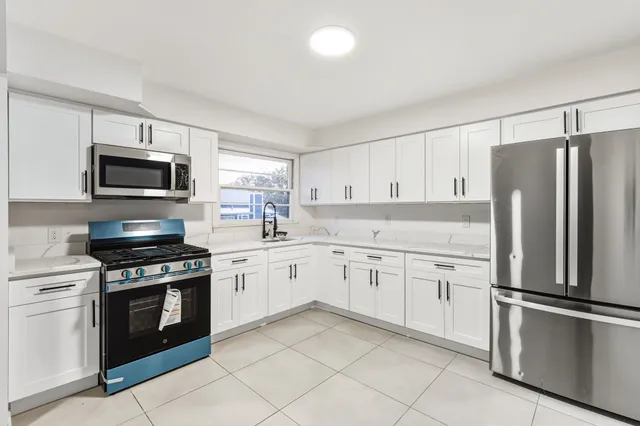 a kitchen with granite countertop cabinets stainless steel appliances and a counter space
