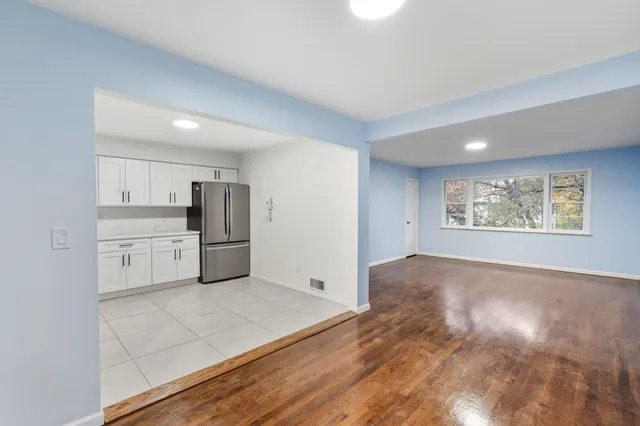 a view of kitchen with granite countertop cabinets and refrigerator