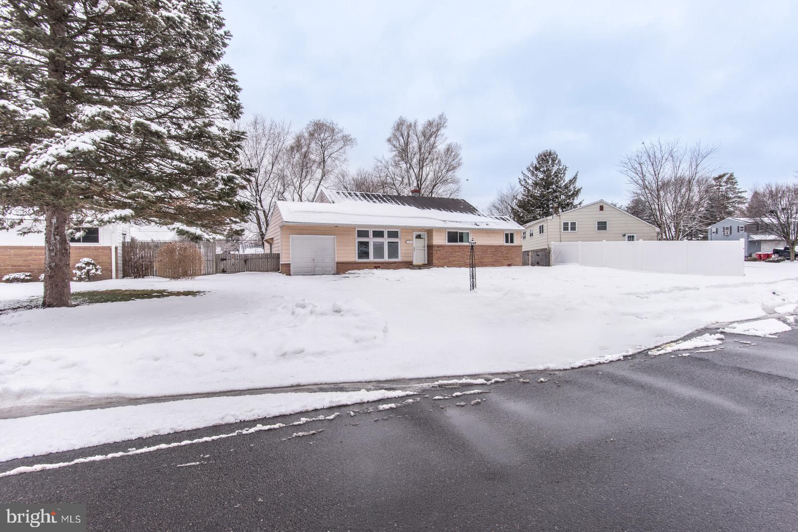 a view of a large white house with a snow on the road