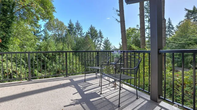 a view of a balcony with wooden floor next to a yard
