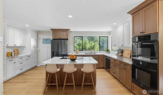 a kitchen with granite countertop white cabinets and stainless steel appliances