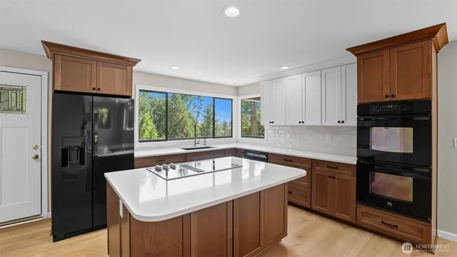 a kitchen that has a sink stainless steel appliances a counter space and a window