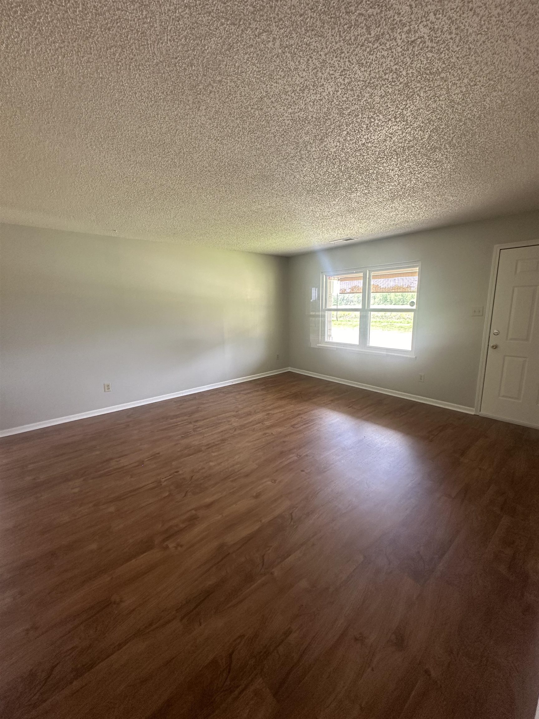 7882 Quito Road Millington, TN 38053 - Photo 2 of 9 an empty room with wooden floor and windows
