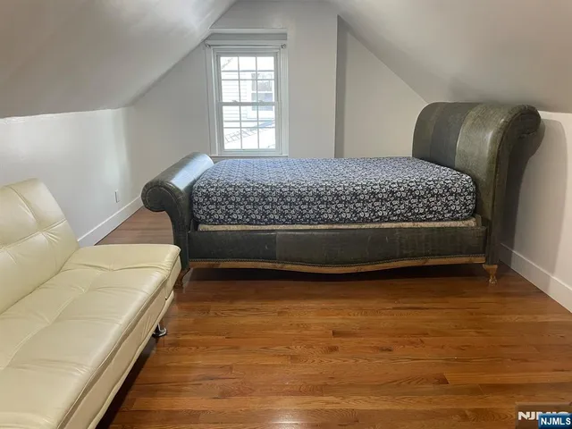 an empty room with wooden floor closet and windows