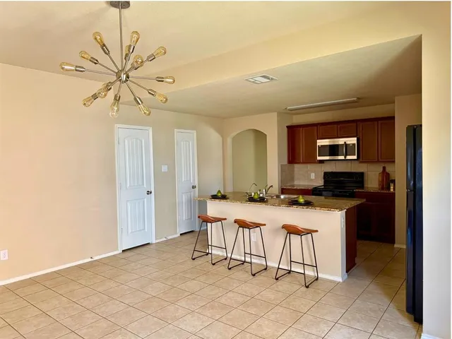 a room with a table chairs and a refrigerator